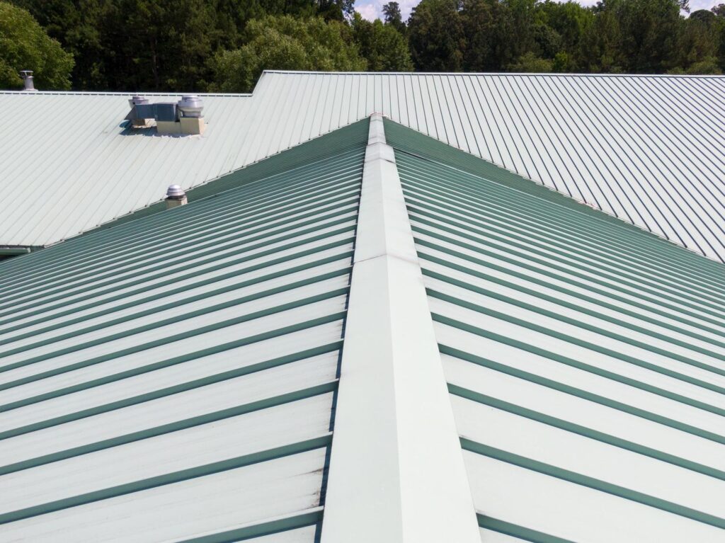 Roofing company near me in Weaverville, NC, sealing damaged flashing on a metal roof